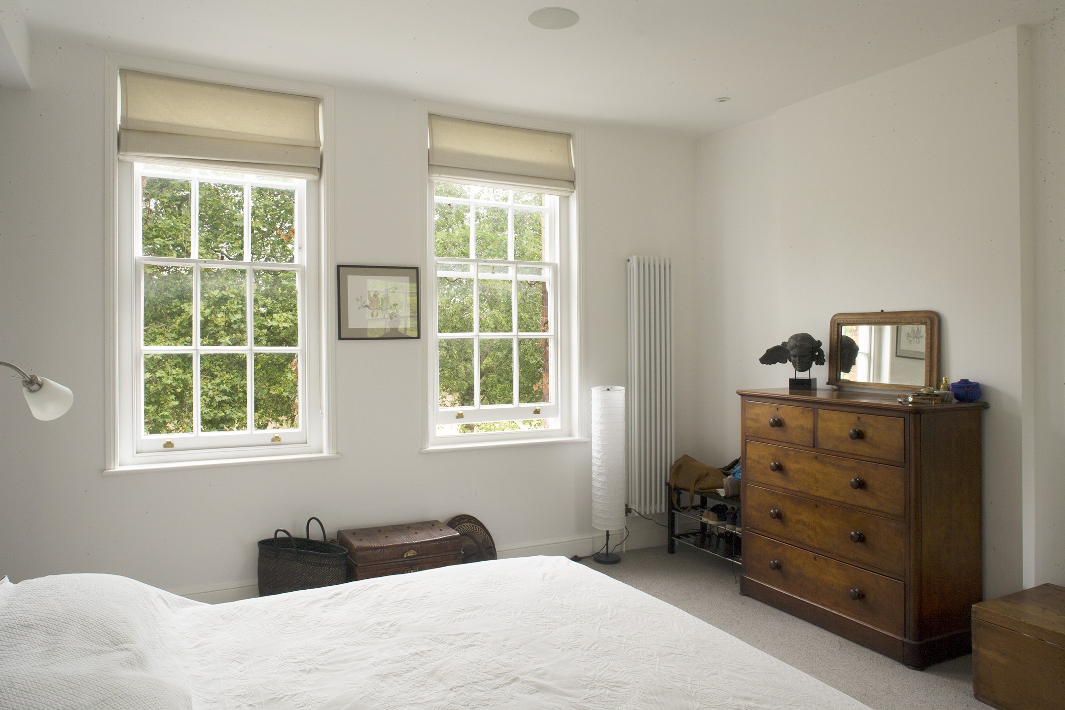 Internal Bedroom with double bed and timber storage. White painted sash windows. Internal decorations to a Grade II listed building
